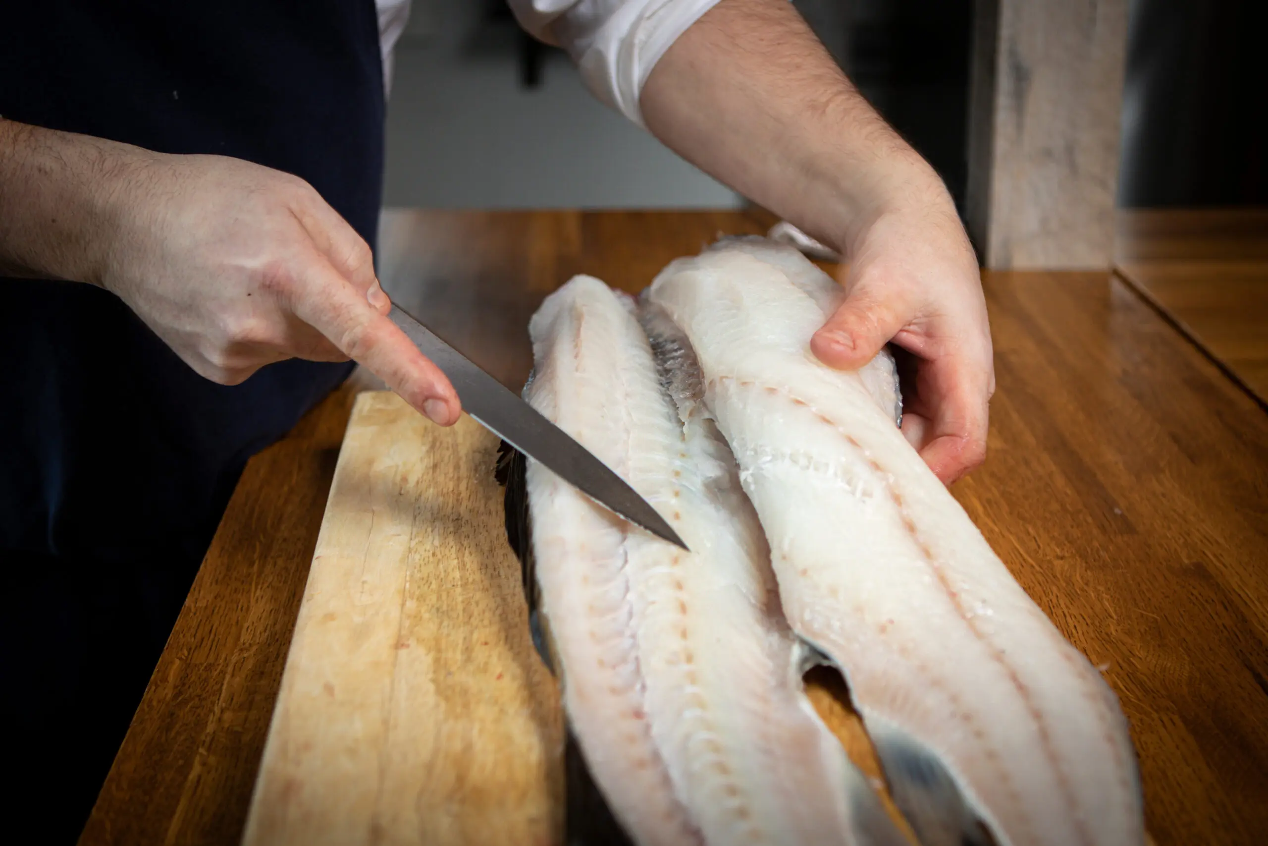 frisch filetierter Skrei auf einem Holzbrett.