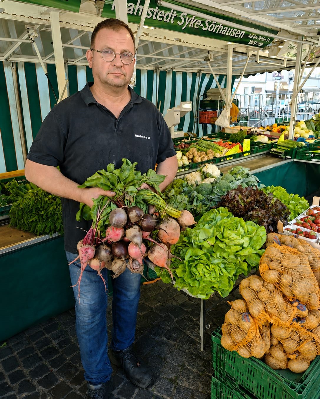 Andreas Mahlstedt steht an seinem Stand mit einem Bund bunter Bete.