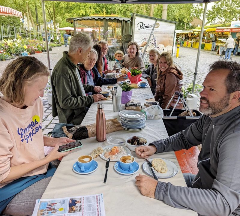 Personen frühstücken auf dem Findorffmarkt an einem Tisch